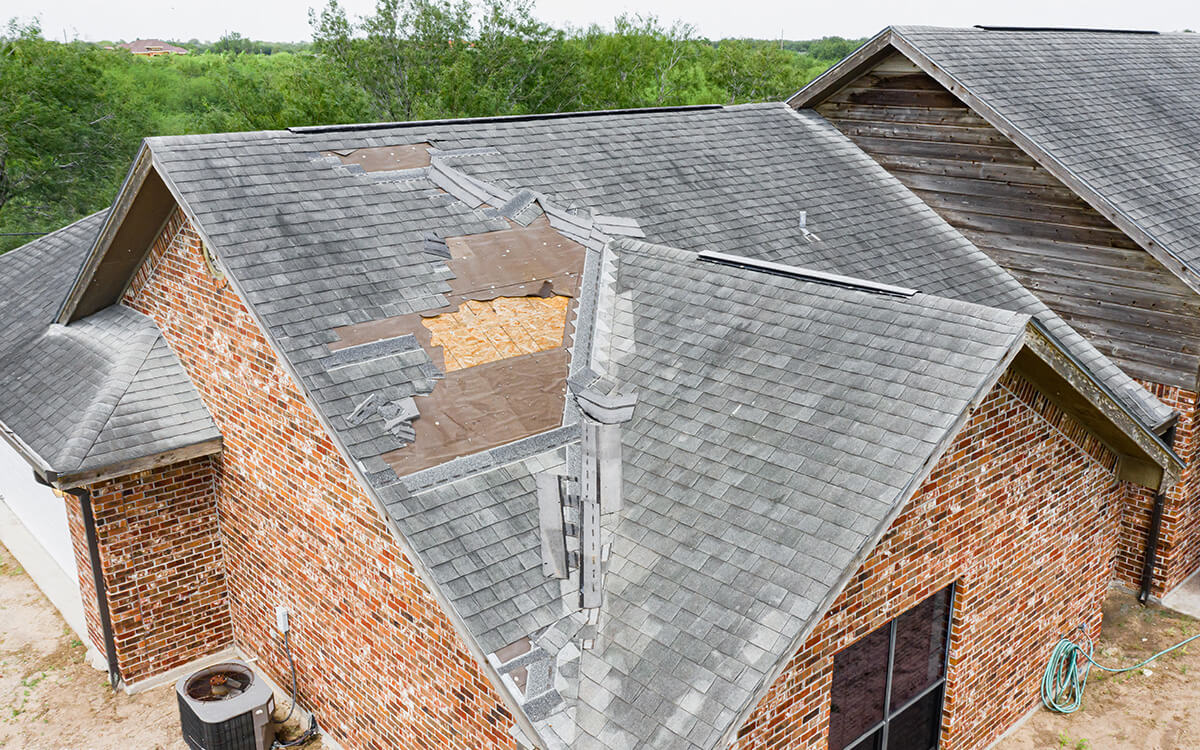 Residential home with severe roof damage in need of a roof replacement